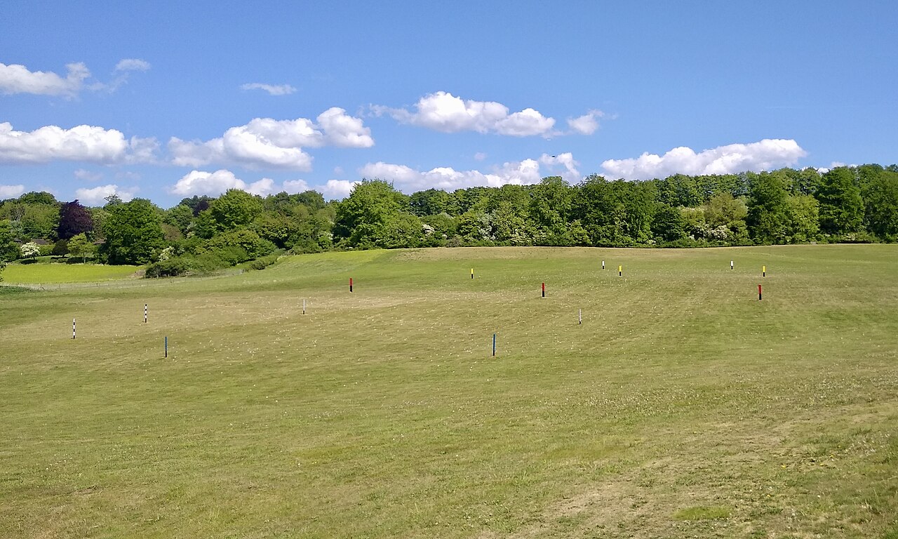 A driving range at Puttenham Golf Club in Surrey, England, with golfers hitting from covered bays